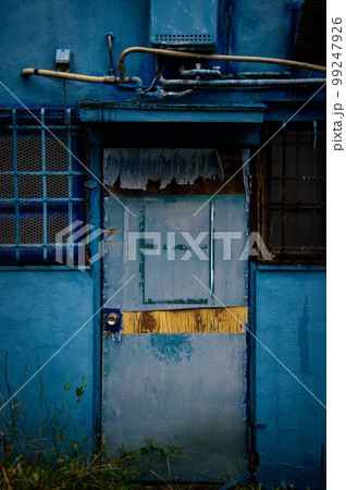 青いペンキで塗られた古びた家のドア 99247926