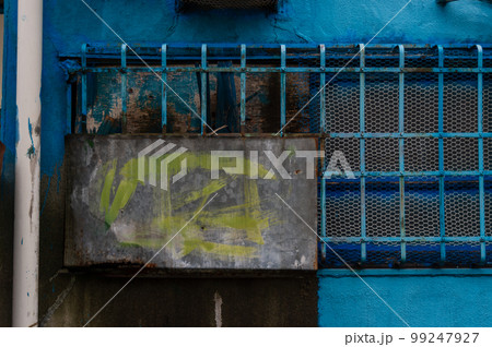 青いペンキで塗られた古びた家の鉄格子　窓 99247927