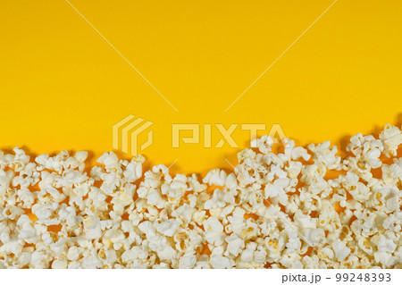 Fresh popcorn on a yellow background with copy space. Top view. Cinema and entertainment concept Fresh popcorn on a yellow background with copy space. Top view. Cinema and entertainment concept 99248393
