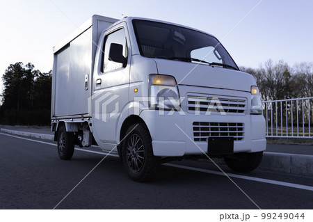 道路の路肩で停車する軽貨物車両 99249044