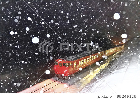 雪降る冬の氷見線（走り去る列車を後方から撮影） 99249129