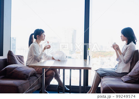 同僚と一緒にランチを食べるビジネスウーマン 99249574