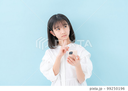 女の子　悩む　スマートフォン 99250196
