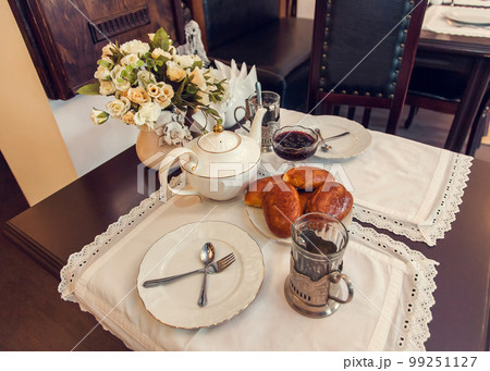 A set table for tea drinking in retro style of USSR times with baked pies. 99251127