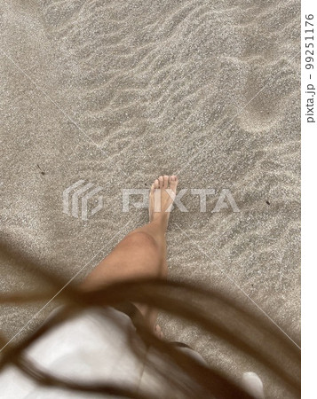 foot on the sand and blurred hair foot on the sand and blurred hair 99251176