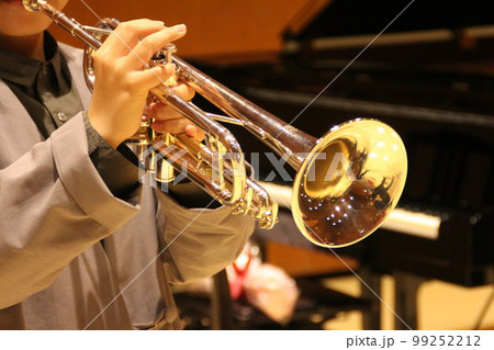 少年が吹くトランペットとホールのグランドピアノ 99252212