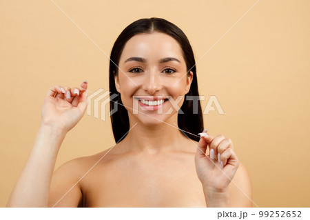 Beautiful Young Indian Woman Holding Dental Floss And Smiling At Camera 99252652
