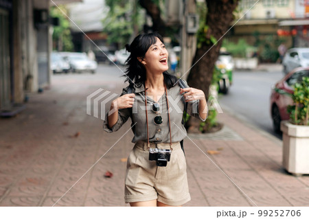 Young Asian woman backpack traveler enjoying street cultural local place and smile. Traveler checking out side streets. Young Asian woman backpack traveler enjoying street cultural local place and smile. Traveler checking out side streets. 99252706