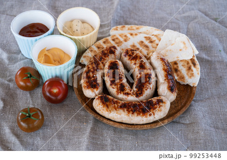 Grilled sausages with sauce and vegetable Grilled sausages with sauce and vegetable 99253448