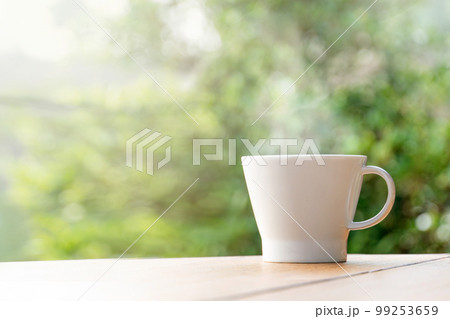 Cup with tea on table over mountains landscape with sunlight. Beauty nature background Cup with tea on table over mountains landscape with sunlight. Beauty nature background 99253659