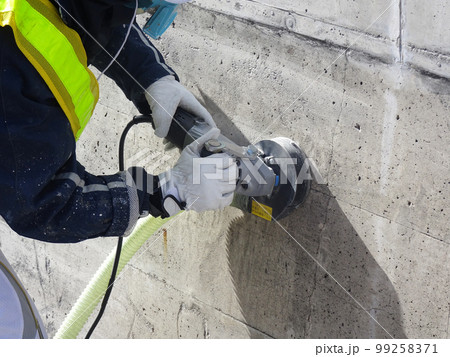 集塵サンダーでコンクリート表面の素地調整をしている様子 99258371