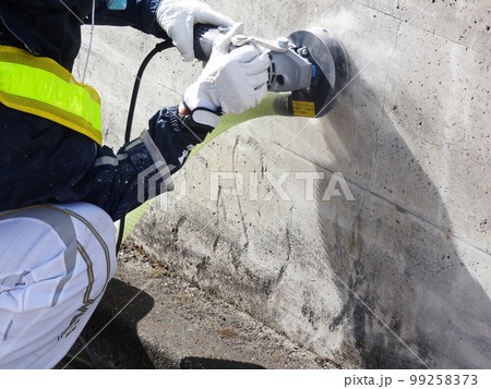 集塵サンダーでコンクリート表面の素地調整をしている様子 99258373