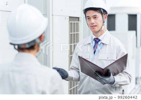ビルの屋上で相談をする作業員 ビルの屋上で相談をする作業員 99260442