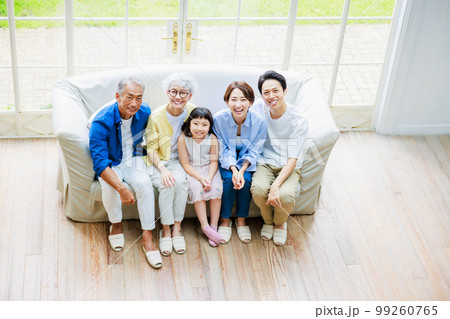 リビングのソファーに座る三世代家族 99260765