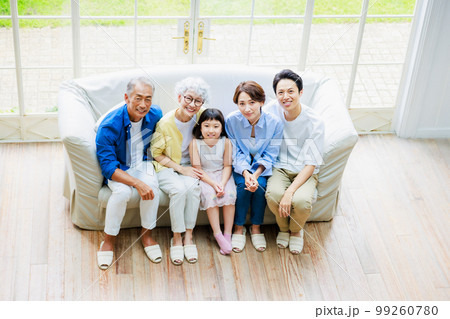 リビングのソファーに座る三世代家族 99260780