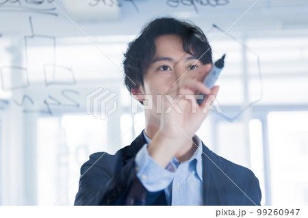 ガラスにアイディアを書き出す男性 99260947