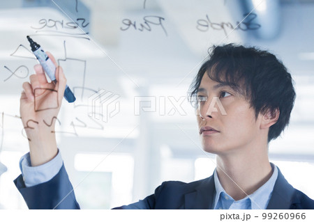 ガラスにアイディアを書き出す男性 99260966