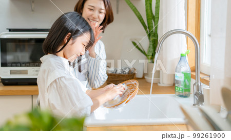 食器洗いを手伝う女の子　親子 99261900