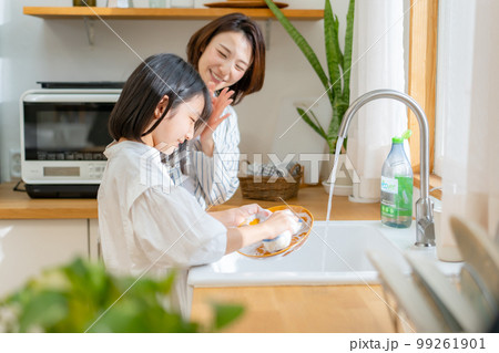 食器洗いを手伝う女の子　親子 99261901