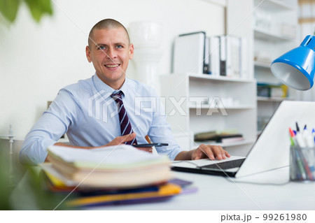 Confident adult man working at office 99261980