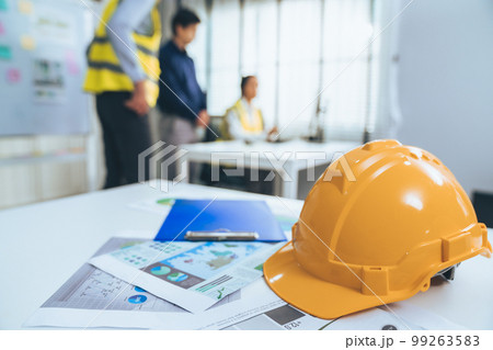 Concept of engineering meeting with protective helmet for competent engineer. Concept of engineering meeting with protective helmet for competent engineer. 99263583