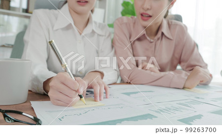 Two young enthusiastic businesswoman working together in the office workspace. 99263700