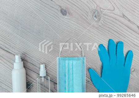 protective mask, gloves and antiseptics on a wooden background 99265646