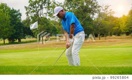 Golfer playing golf in the evening golf course Golfer playing golf in the evening golf course 99265804