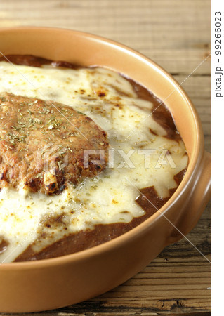 たっぷりのチーズとハンバーグが乗っている焼きカレー たっぷりのチーズとハンバーグが乗っている焼きカレー 99266023