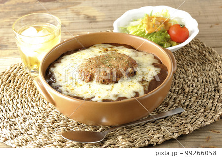 たっぷりのチーズとハンバーグが乗っている焼きカレーとサラダ たっぷりのチーズとハンバーグが乗っている焼きカレーとサラダ 99266058