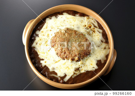 たっぷりのチーズとハンバーグが乗っている焼きカレーを黒背景で俯瞰撮影 たっぷりのチーズとハンバーグが乗っている焼きカレーを黒背景で俯瞰撮影 99266160