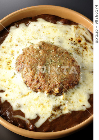 たっぷりのチーズとハンバーグが乗っている焼きカレーを黒背景で俯瞰撮影 たっぷりのチーズとハンバーグが乗っている焼きカレーを黒背景で俯瞰撮影 99266174