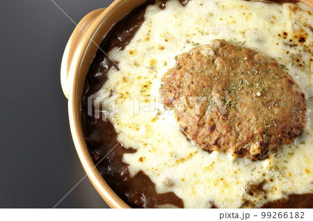 たっぷりのチーズとハンバーグが乗っている焼きカレーを黒背景で俯瞰撮影 たっぷりのチーズとハンバーグが乗っている焼きカレーを黒背景で俯瞰撮影 99266182