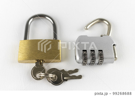白背景で撮影した鍵の開いた南京錠とダイアルロック 99268688