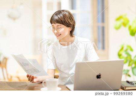 自宅に仕事を持ち帰って作業をする若い女性 自宅に仕事を持ち帰って作業をする若い女性 99269380