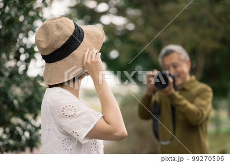 女性の写真を撮るシニア男性 99270596
