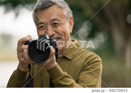 写真を撮るシニア男性 99270655