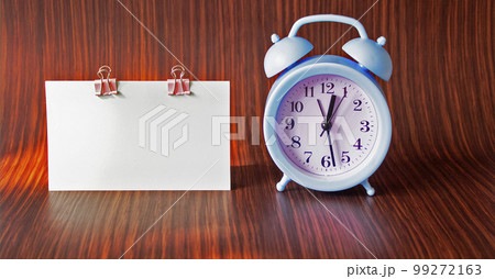 Light sticker block and blue alarm clock on a wooden table background. Space for text. Light sticker block and blue alarm clock on a wooden table background. Space for text. 99272163