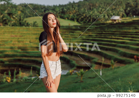 Attractive woman posing on rise terraces with morning sun light Attractive woman posing on rise terraces with morning sun light 99275140