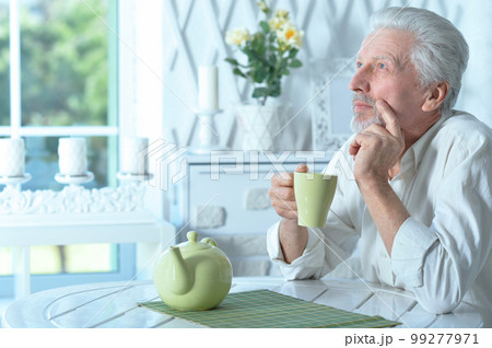 Portrait of smiling old man drinking tea at home 99277971
