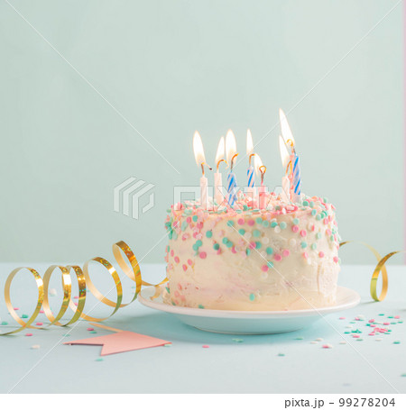 Festive cake with candles on blue background, sequins serpentine, confetti. concept of holiday Festive cake with candles on blue background, sequins serpentine, confetti. concept of holiday 99278204
