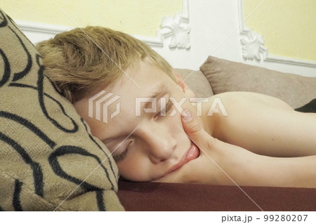 10 year old Caucasian boy fell asleep on the couch. Children's dream. Sleep problems, falling asleep, insomnia, fatigue. The concept of health, mode of wakefulness and rest, education and prevention. 10 year old Caucasian boy fell asleep on the couch. Children's dream. Sleep problems, falling asleep, insomnia, fatigue. The concept of health, mode of wakefulness and rest, education and prevention. 99280207