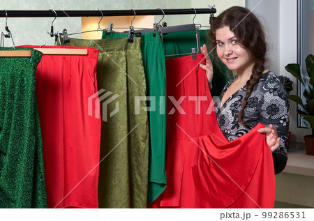 Portrait of a woman on the background of clothes in the dressing room 99286531