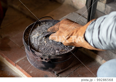 山小屋の暖炉で古いダッチオーブンを使い料理をしているところ 99286568