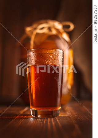 glass and three-liter jar with kombucha 99287557