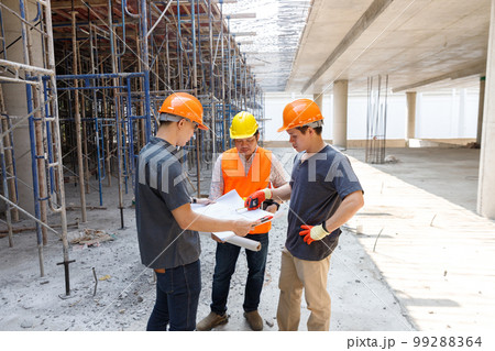 Concept of construction. Engineer, architect and designer working together at the construction site, Foreman or engineer checking the accuracy of the construction work by using blueprints.. 99288364