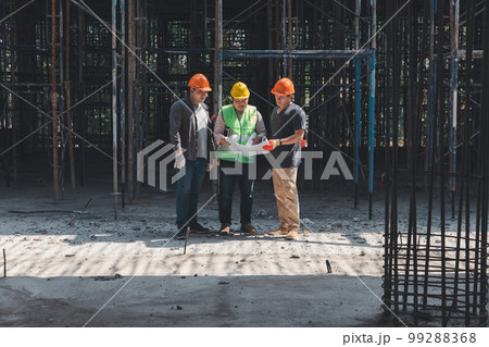Concept of construction. Engineer, architect and designer working together at the construction site, Foreman or engineer checking the accuracy of the construction work by using blueprints.. Concept of construction. Engineer, architect and designer working together at the construction site, Foreman or engineer checking the accuracy of the construction work by using blueprints.. 99288368