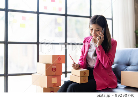 Startup small business SME, Entrepreneur owner using smartphone or tablet taking receive and checking online purchase shopping order to preparing pack product box. Selling online ideas concept 99290740