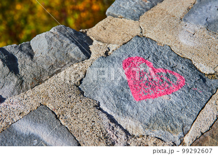 Stone wall detail of pink heart graffiti Stone wall detail of pink heart graffiti 99292607