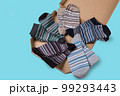 Striped socks of different colors, folded in half and laid out in a circle in a box, like a pizza, concept, close-up 99293443